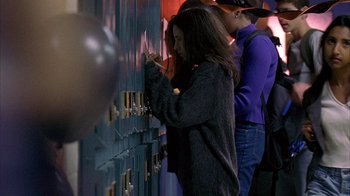 A woman is writing on a blue locker