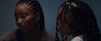Movie still from “Girlhood” (2014), directed by Céline Sciamma – Two young girls with long hair and braids; Close Up shot, Over the shoulder angle