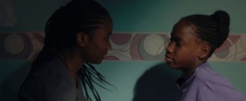 Movie still from “Girlhood” (2014), directed by Céline Sciamma – Two young girls face each other in a room; Close Up shot, Over the shoulder angle