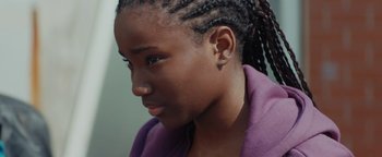 Movie still from “Girlhood” (2014), directed by Céline Sciamma – A person wearing a purple shirt; Close Up shot, High angle
