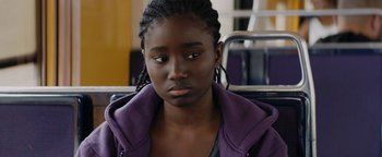 Movie still from “Girlhood” (2014), directed by Céline Sciamma – A young black woman sitting on a bench; Close Up shot, Over the shoulder angle