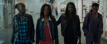Movie still from “Girlhood” (2014), directed by Céline Sciamma – A group of young women standing next to each other in a building; Medium shot, High angle