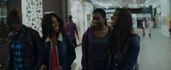 Movie still from “Girlhood” (2014), directed by Céline Sciamma – A group of young women laughing together in a mall; Medium shot, Over the shoulder angle