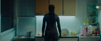 Movie still from “Girlhood” (2014), directed by Céline Sciamma – A woman standing in a kitchen looking into a sink; Medium shot, Low angle