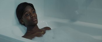 Movie still from “Girlhood” (2014), directed by Céline Sciamma – A woman in a bath tub with a gold chain around her neck; Close Up shot, High angle