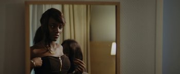 Movie still from “Girlhood” (2014), directed by Céline Sciamma – A woman brushing her hair in front of a mirror; Close Up shot, Over the shoulder angle