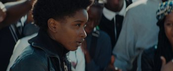 Movie still from “Girlhood” (2014), directed by Céline Sciamma – A person wearing a black jacket; Close Up shot, Over the shoulder angle
