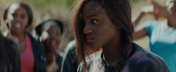 Movie still from “Girlhood” (2014), directed by Céline Sciamma – A person with long brown hair; Close Up shot, Over the shoulder angle
