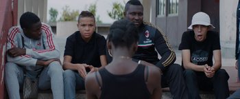 Movie still from “Girlhood” (2014), directed by Céline Sciamma – A group of young people sitting on the ground; Medium shot, Over the shoulder angle
