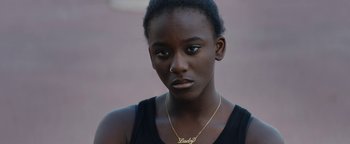 Movie still from “Girlhood” (2014), directed by Céline Sciamma – A woman with a gold necklace and a black shirt; Close Up shot, High angle
