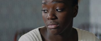Movie still from “Girlhood” (2014), directed by Céline Sciamma – A person looking down at their face; Close Up shot, Over the shoulder angle