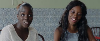Movie still from “Girlhood” (2014), directed by Céline Sciamma – Two people sitting in front of each other in front of a wall; Close Up shot, Over the shoulder angle