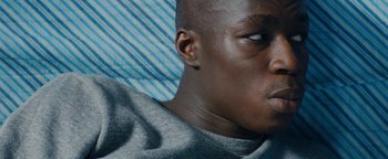 Movie still from “Girlhood” (2014), directed by Céline Sciamma – A man's face with a blue background; Close Up shot, High angle