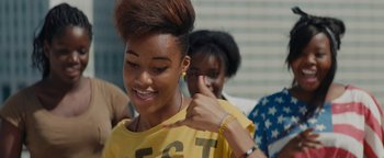 Movie still from “Girlhood” (2014), directed by Céline Sciamma – A young woman is smiling and pointing to her ear; Close Up shot, Low angle