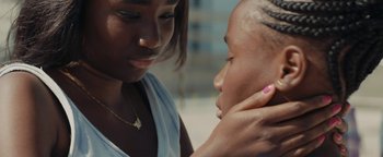 Movie still from “Girlhood” (2014), directed by Céline Sciamma – A young woman is touching the ear of a young girl; Close Up shot, Over the shoulder angle