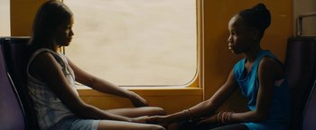 Movie still from “Girlhood” (2014), directed by Céline Sciamma – Two women sitting next to each other on a train; Medium shot, Over the shoulder angle