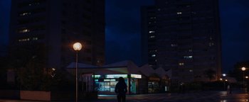 Movie still from “Girlhood” (2014), directed by Céline Sciamma – A person standing in front of a building at night; Extreme Wide shot, Low angle