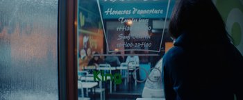Movie still from “Girlhood” (2014), directed by Céline Sciamma – People are sitting at tables in front of a window; Medium shot, Over the shoulder angle