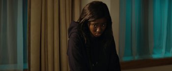 Movie still from “Girlhood” (2014), directed by Céline Sciamma – A woman with long black hair sitting in a room; Close Up shot, Over the shoulder angle