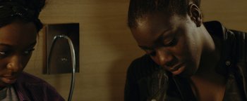 Movie still from “Girlhood” (2014), directed by Céline Sciamma – A person with a microphone in a room; Close Up shot, High angle