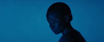 Movie still from “Girlhood” (2014), directed by Céline Sciamma – A young woman with a blue light on her face; Close Up shot, High angle