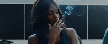 Movie still from “Girlhood” (2014), directed by Céline Sciamma – A woman is smoking a cigarette in front of a window; Close Up shot, Low angle