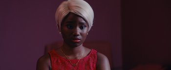 Movie still from “Girlhood” (2014), directed by Céline Sciamma – A young woman with a white turban is wearing a red dress; Close Up shot, High angle