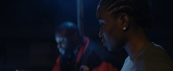 Movie still from “Girlhood” (2014), directed by Céline Sciamma – Two young people sitting in a dark room; Close Up shot, Over the shoulder angle