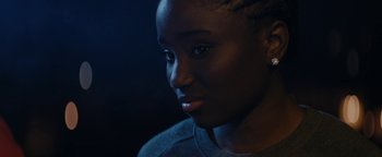 Movie still from “Girlhood” (2014), directed by Céline Sciamma – A person's face in the dark; Close Up shot, Over the shoulder angle