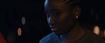 Movie still from “Girlhood” (2014), directed by Céline Sciamma – A person's face in the dark; Close Up shot, Over the shoulder angle