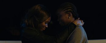 Movie still from “Girlhood” (2014), directed by Céline Sciamma – Two women embracing each other in the dark; Close Up shot, Over the shoulder angle