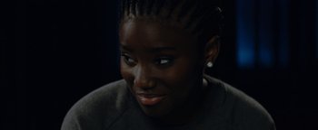 Movie still from “Girlhood” (2014), directed by Céline Sciamma – A person with a smile on their face; Close Up shot, Over the shoulder angle
