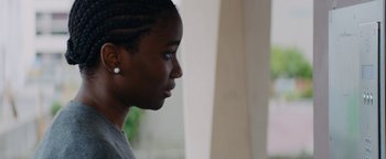 Movie still from “Girlhood” (2014), directed by Céline Sciamma – A person's face in a room; Close Up shot, Over the shoulder angle