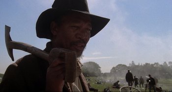 Movie still from “Glory” (1989), directed by Edward Zwick – A man in a cowboy hat holding a wooden stick; Close Up shot, Low angle