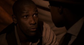 Movie still from “Glory” (1989), directed by Edward Zwick – Two men are sitting in a dimly - lit room; Close Up shot, High angle