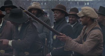 Movie still from “Glory” (1989), directed by Edward Zwick – A group of men standing next to each other holding guns; Medium shot, Over the shoulder angle