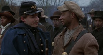 Movie still from “Glory” (1989), directed by Edward Zwick – Two men in military garb talking to each other; Close Up shot, Over the shoulder angle