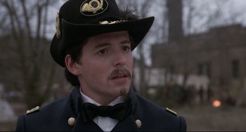 Movie still from “Glory” (1989), directed by Edward Zwick – A person wearing a uniform and a hat; Close Up shot, Over the shoulder angle