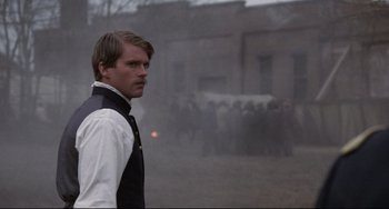 Movie still from “Glory” (1989), directed by Edward Zwick – A man standing in front of a group of horses; Close Up shot, Over the shoulder angle