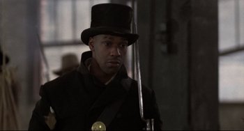 Movie still from “Glory” (1989), directed by Edward Zwick – A man wearing a top hat and holding a sword; Close Up shot, Over the shoulder angle