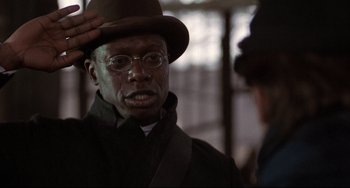 Movie still from “Glory” (1989), directed by Edward Zwick – A man in a hat and glasses is saluting; Close Up shot, Low angle