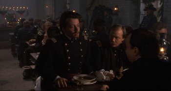 Movie still from “Glory” (1989), directed by Edward Zwick – Two men in military uniforms sitting at a table; Medium shot, Over the shoulder angle