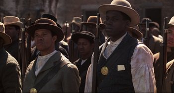 Movie still from “Glory” (1989), directed by Edward Zwick – A group of men wearing hats and holding guns; Medium shot, Low angle