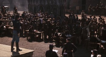 Movie still from “Glory” (1989), directed by Edward Zwick – A crowd of people sitting around tables in a courtyard; Extreme Wide shot, High angle