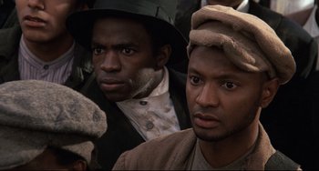 Movie still from “Glory” (1989), directed by Edward Zwick – Two men are standing together and one of them is wearing a hat; Close Up shot, High angle