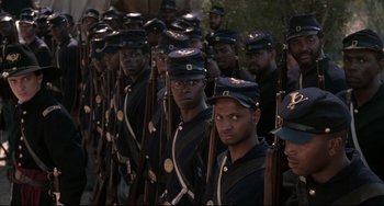 Movie still from “Glory” (1989), directed by Edward Zwick – A large group of men in uniform are standing in a line; Medium shot, High angle
