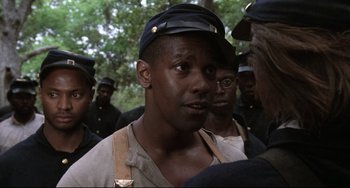 Movie still from “Glory” (1989), directed by Edward Zwick – A group of men standing next to each other in a forest; Close Up shot, Over the shoulder angle
