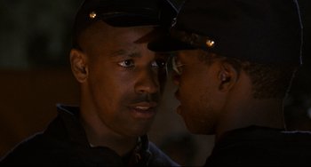Movie still from “Glory” (1989), directed by Edward Zwick – Two police officers talking to each other in a dark room; Close Up shot, Over the shoulder angle