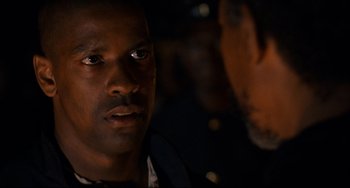 Movie still from “Glory” (1989), directed by Edward Zwick – A man in a dark room looking at the camera; Close Up shot, Over the shoulder angle