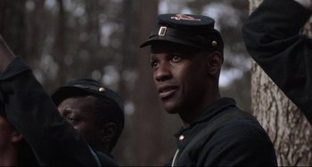 Movie still from “Glory” (1989), directed by Edward Zwick – A man in a military uniform is standing next to another man in a military uniform; Close Up shot, Low angle